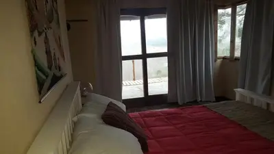 a bedroom with a bed in front of a window at Gran Cabaña en Villa Yacanto in Villa Yacanto