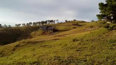 a house sitting on top of a grassy hill at Gran Cabaña en Villa Yacanto in Villa Yacanto