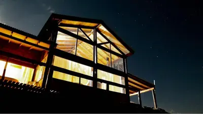 a building with a lot of windows at night at Gran Cabaña en Villa Yacanto in Villa Yacanto