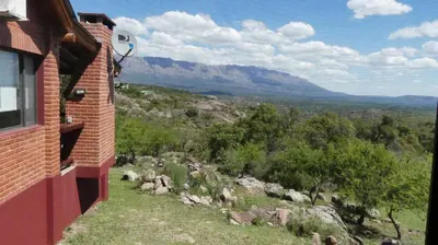 a brick building with a view of a mountain at Cabañas Pampa in Mina Clavero