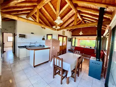 a kitchen and dining room with a table and chairs at Cabañas Pampa in Mina Clavero
