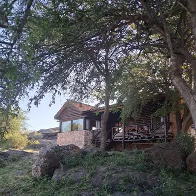 a house on top of a hill with trees at Cabañas Pampa in Mina Clavero