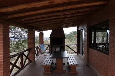 a porch of a house with a wood stove at Cabañas Pampa in Mina Clavero