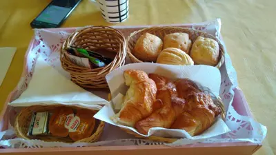 three baskets of bread and pastries on a table at Posta Los Reartes in Los Reartes