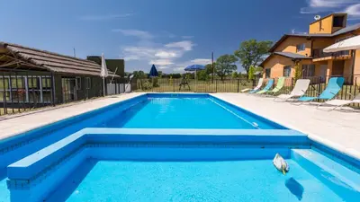 a swimming pool with blue water in a yard at Posta Los Reartes in Los Reartes