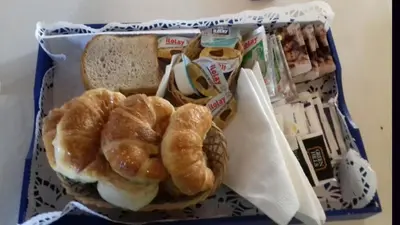 a basket with a sandwich and bread on a table at Posta Suites Apart - Los Reartes in Los Reartes