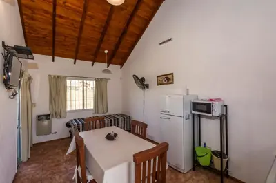 a kitchen with a table and a white refrigerator at Posta Suites Apart - Los Reartes in Los Reartes