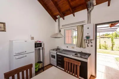 a kitchen with a white refrigerator and a sink at Posta Suites Apart - Los Reartes in Los Reartes