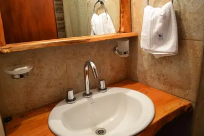 a bathroom with a white sink and a mirror at Posta Suites Apart - Los Reartes in Los Reartes