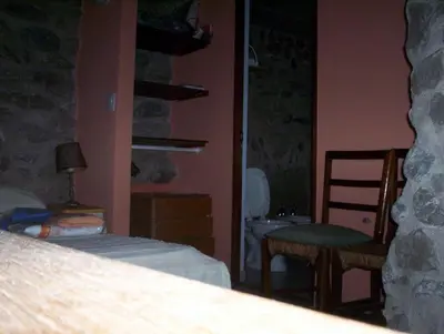 a bedroom with a bed and a chair and a sink at Verde Niña Casas Serranas in Cortaderas