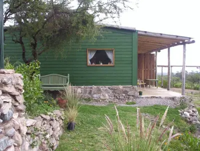 a green house with a dog sticking its head out the window at Verde Niña Casas Serranas in Cortaderas