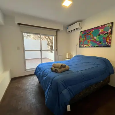 a bedroom with a blue bed with a towel on it at Edificio Torre Agora in Cordoba