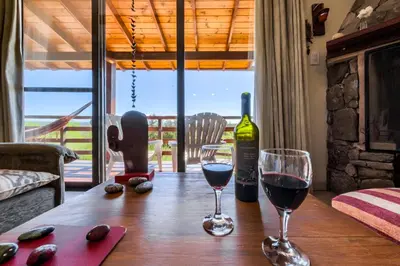 a table with two glasses of wine and a bottle at Terrazas de Piedra in Santa Rosa de Calamuchita