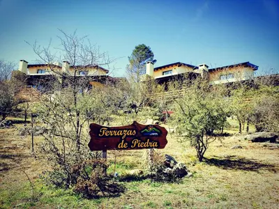 a sign in the middle of a field with houses at Terrazas de Piedra in Santa Rosa de Calamuchita