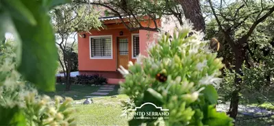 a small orange house with a tree in front of it at Punto Serrano in Carpintería