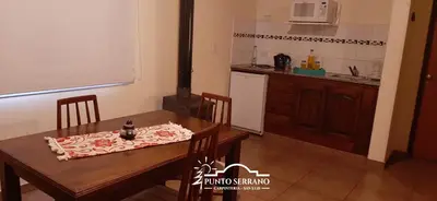 a kitchen with a wooden table and a dining room at Punto Serrano in Carpintería