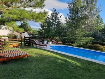 a backyard with a swimming pool and a lawn with benches at Lomas del Vergel in Los Reartes