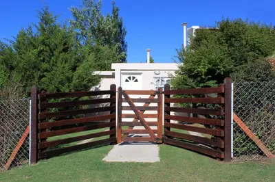 a wooden fence with a gate in front of a house at Lomas del Vergel in Los Reartes