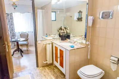 a bathroom with a sink and a toilet and a mirror at Virreinato Hotel Boutique in Cordoba
