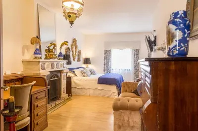 a room with a bedroom with a bed and a fireplace at Virreinato Hotel Boutique in Cordoba