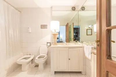 a bathroom with two toilets and a sink and a mirror at Virreinato Hotel Boutique in Cordoba
