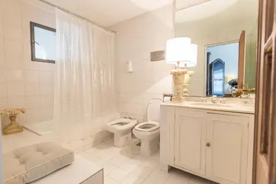 a white bathroom with a toilet and a sink at Virreinato Hotel Boutique in Cordoba