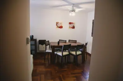 a dining room table with chairs and a ceiling fan at 4 PERSONAS A 150 Mts SANATORIO ALLENDE in Cordoba