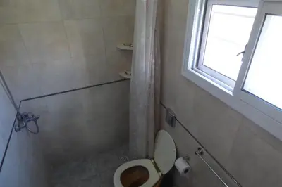 a bathroom with a toilet and a window at Departamento Centrico in Villa Carlos Paz