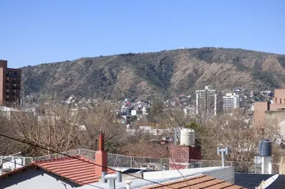 a view of a city with a mountain in the background at Departamento Centrico in Villa Carlos Paz