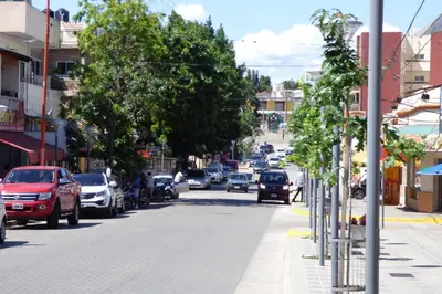 a busy street in a city with cars parked at Departamento Centrico in Villa Carlos Paz