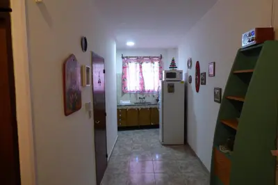 a hallway of a kitchen with a refrigerator and a window at Departamento Centrico in Villa Carlos Paz