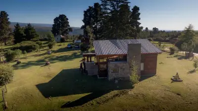 an overhead view of a small house in a field at La Azotea cabañas & suites in La Cumbrecita