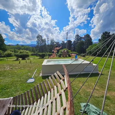 a fence in front of a playground with a pool at La Azotea cabañas & suites in La Cumbrecita