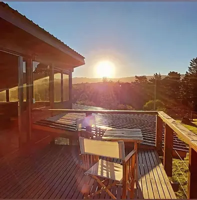 a deck with a table and chairs on a house at La Azotea cabañas & suites in La Cumbrecita