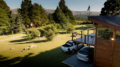 a car parked in a yard next to a house at La Azotea cabañas & suites in La Cumbrecita