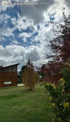 a building in the middle of a grass field at La Azotea cabañas & suites in La Cumbrecita