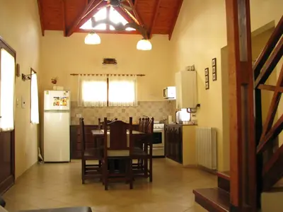 a kitchen with a table and chairs and a refrigerator at Don Gregorio Spa in Merlo
