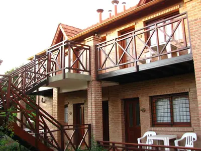 a balcony on the side of a house with white chairs at Don Gregorio Spa in Merlo