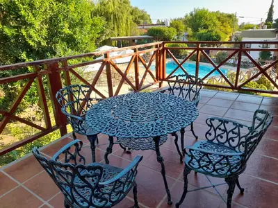 a table and chairs on a balcony with a pool at Don Gregorio Spa in Merlo