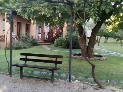 a park bench sitting next to a tree at Don Gregorio Spa in Merlo