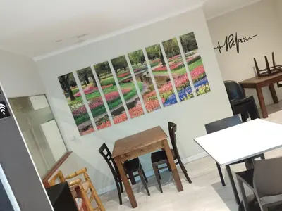a room with tables and chairs and paintings on the wall at Hotel Alto Parana in Cordoba