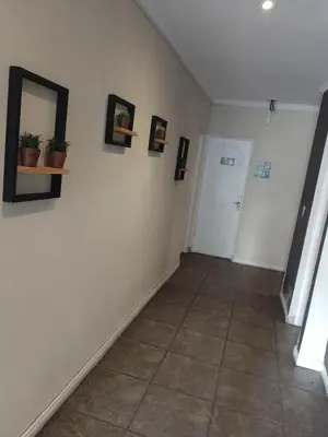 a hallway with white walls and a tile floor at Hotel Alto Parana in Cordoba