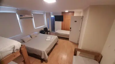 a small room with a bed and a refrigerator at Hotel Alto Parana in Cordoba