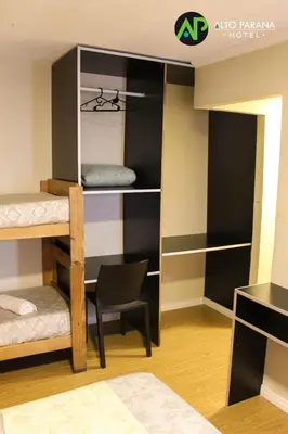 a room with bunk beds with a chair and a desk at Hotel Alto Parana in Cordoba
