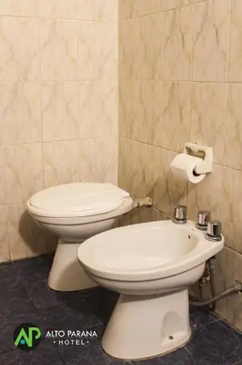 a bathroom with a toilet and a sink at Hotel Alto Parana in Cordoba