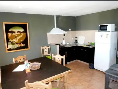 a kitchen with a table and a white refrigerator at Cabañas el Recodo de Potrero in Potrero de Garay