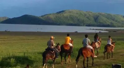 a group of people riding horses in a field at Cabañas el Recodo de Potrero in Potrero de Garay