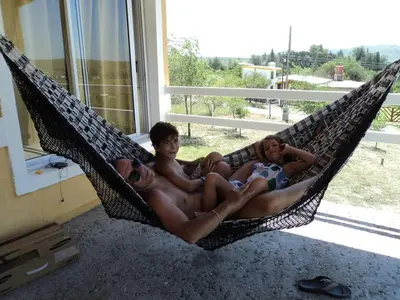 a group of three men sitting in a hammock at Cabañas el Recodo de Potrero in Potrero de Garay