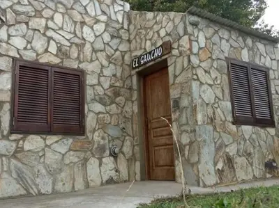 a stone building with a door and a sign on it at Hostal 