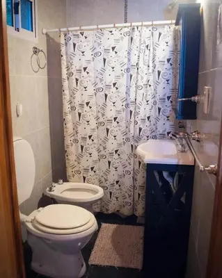 a bathroom with a toilet and a shower curtain at Hostal 